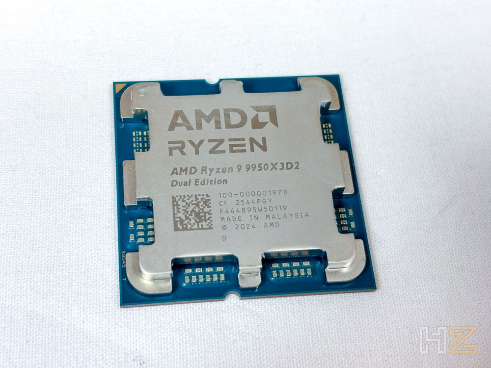 Primer plano del procesador AMD Ryzen 9 9950X3D2 Dual Edition sobre una superficie blanca, mostrando el diseño del IHS y las inscripciones grabadas con láser.
