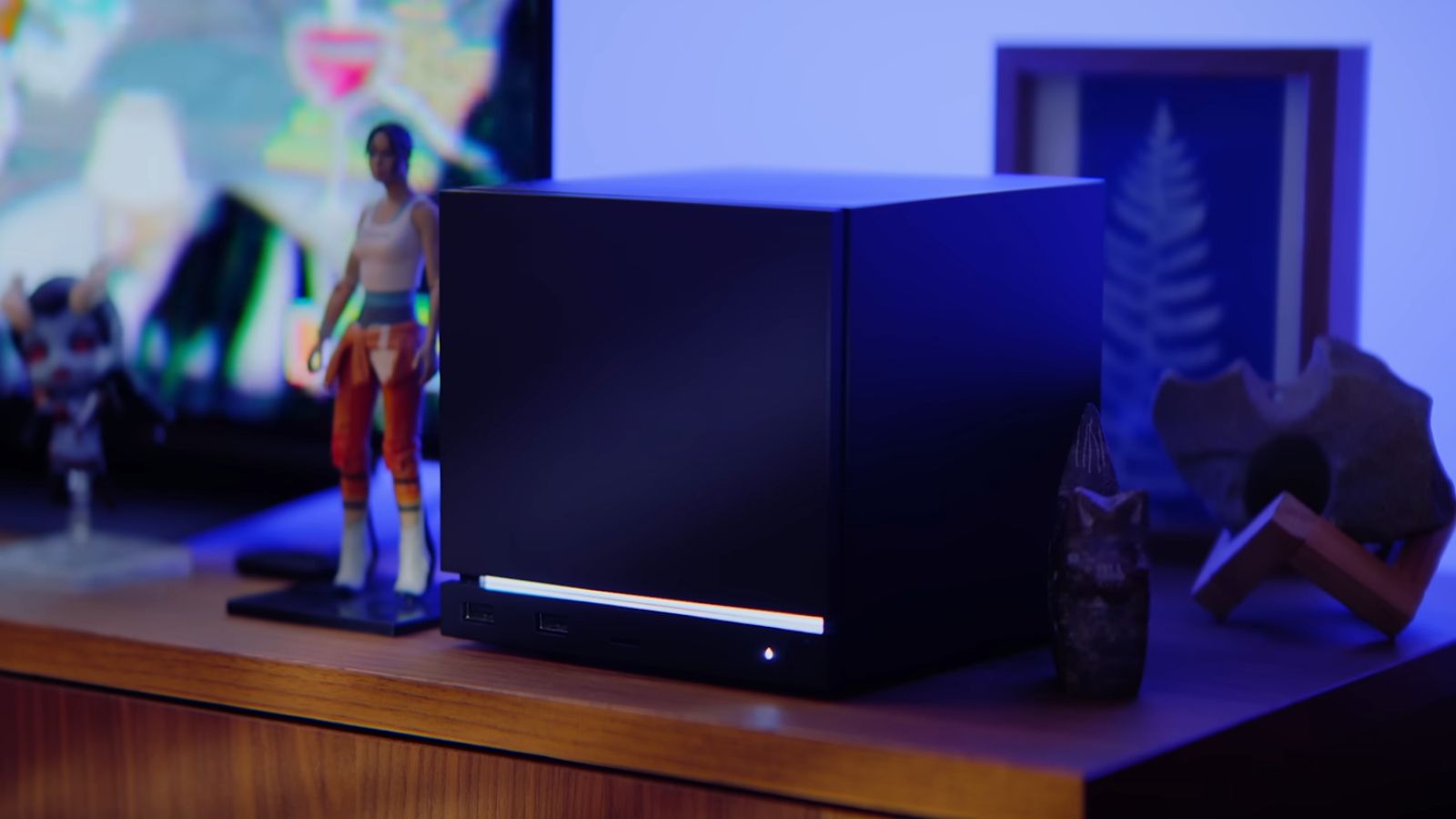 Imagen oficial de la Steam Machine 2026, un mini PC cúbico de color oscuro con iluminación LED azul en la rejilla de ventilación superior.