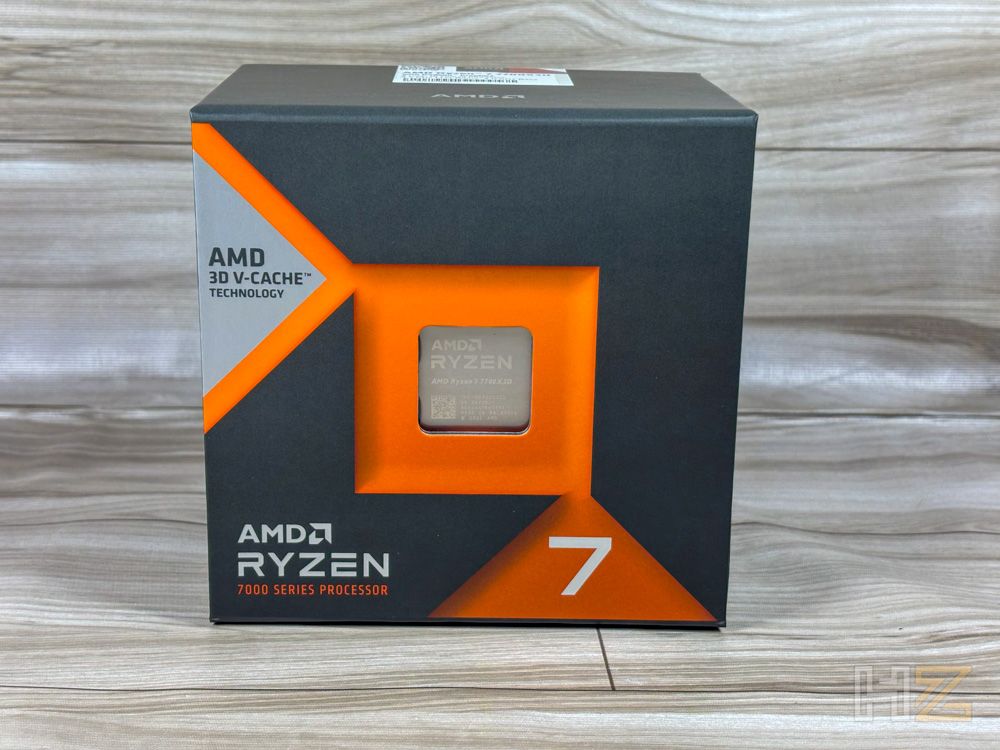 Caja oficial de un procesador AMD Ryzen 7 serie 7000 con tecnología 3D V-Cache sobre una superficie de madera.