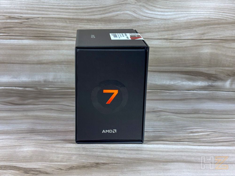 Caja negra de un procesador AMD Ryzen 7 con el número siete en color naranja sobre fondo de madera.