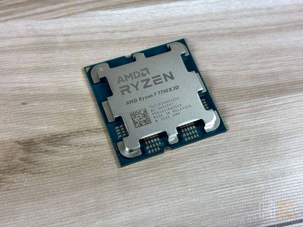 Procesador AMD Ryzen 7 7700X3D con tecnología 3D V-Cache sobre una superficie de madera clara.