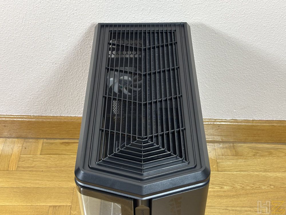 Vista superior de la rejilla de ventilación negra con diseño geométrico de la caja de PC Nox Hummer Anvil sobre suelo de parqué.