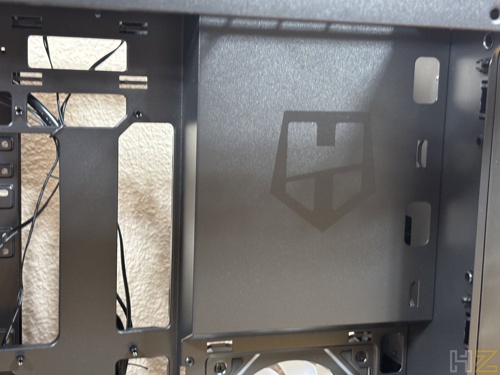 Interior de una caja de ordenador gris con el logotipo de la marca Hummer grabado en el panel central de metal.