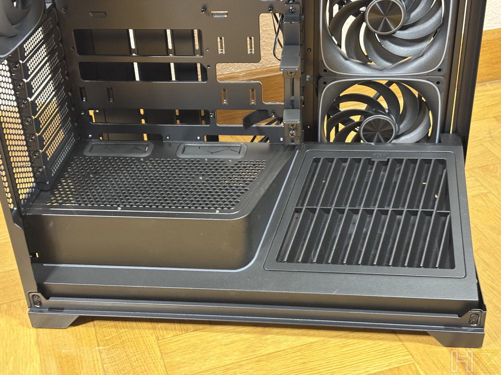 Vista interior del compartimento inferior de una caja de PC Nox Hummer Blade con cubrefuente ventilado y ventiladores laterales.