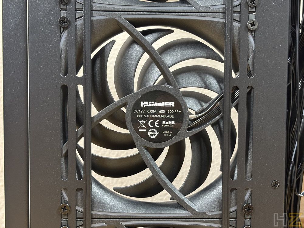 Primer plano del ventilador trasero Nox Hummer Blade instalado en el chasis, mostrando el diseño de las aspas curvas y la etiqueta técnica del motor.