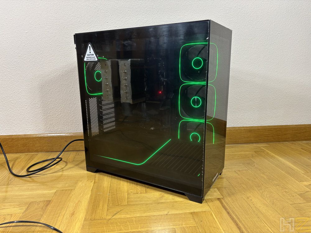 Chasis de PC Nox Hummer Blade en color negro con paneles de cristal templado y ventiladores con iluminación LED verde sobre un suelo de parquet.