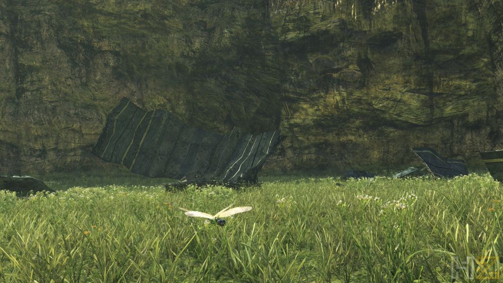 Mariposa blanca volando sobre una llanura de hierba verde frente a una pared de roca y restos metálicos en Xenoblade Chronicles Definitive Edition.