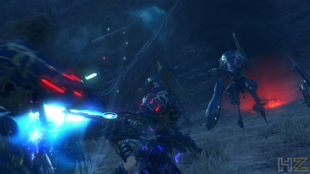 Combate nocturno en Xenoblade Chronicles Definitive Edition con efectos de luz azul y enemigos mecánicos en un entorno oscuro.
