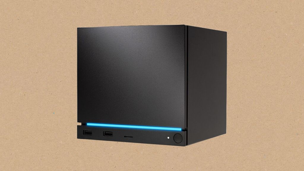 Consola Steam Machine con formato de cubo negro y una línea de luz led azul en el frontal sobre fondo neutro.