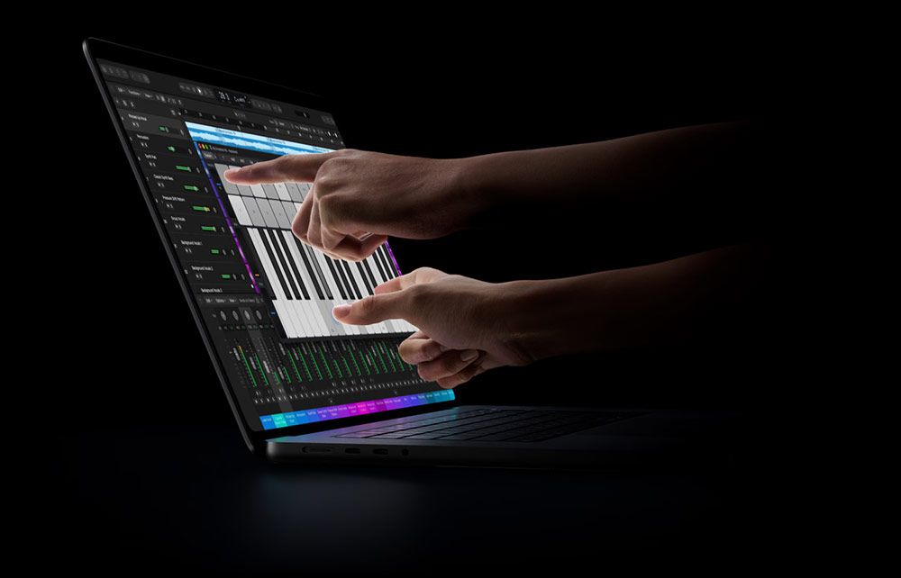 Manos interactuando con la pantalla táctil de un MacBook Pro OLED mientras se ejecuta un software de edición musical.